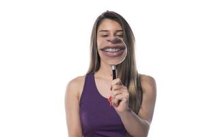 lachend vrouw houdt een vergroten glas in voorkant van haar mond foto