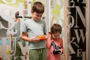 broer met zus Speel afgelegen controle in kinderen kamer. foto