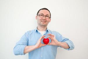 gepassioneerd jong Mens Holding rood hart in de buurt borst. liefde, romantiek, valenrines dag concept foto