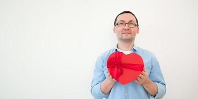 gelukkig Mens Holding hartvormig geschenk box.verjaardag, valentijnsdag dag,8 maart copyspace banier foto