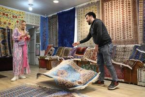 samarkand.oezbekistan. april 06, 2022. samarkand zijde fabriek. Mens shows een jong meisje tapijt foto