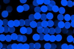 ongericht abstract donker blauw bokeh Aan zwart achtergrond. onscherp en wazig veel ronde licht foto