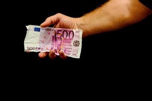 hand- Holding contant geld Aan donker achtergrond foto