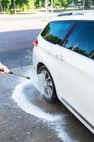 hand- het wassen met hoog druk water in een auto wassen buiten. een Jet van schuim. de concept van hand- wassen, Zelfbediening. foto