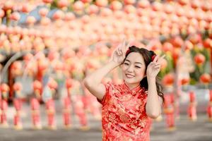 gelukkig Chinese nieuw jaar. Aziatisch vrouw vervelend traditioneel cheongsam qipao jurk poseren konijn in Chinese boeddhistisch tempel. vieren Chinese maan- nieuw jaar, feestelijk seizoen vakantie. foto