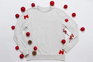 dichtbij omhoog wit blanco sjabloon sweater met kopiëren ruimte en Kerstmis vakantie concept. top visie mockup capuchon en rood vakantie decoraties Aan wit achtergrond. gelukkig nieuw jaar accessoires. Kerstmis kleding foto