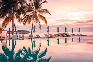 luxe zwemmen zwembad Aan de strand, rustig tafereel van exotisch tropisch landschap met kopiëren ruimte, zomer achtergrond voor vakantie vakantie. mooi zwembad en zonsondergang lucht. luxueus tropisch strand foto