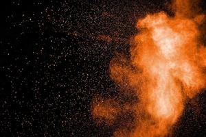 oranje kleur poeder explosie wolk Aan zwart achtergrond. foto