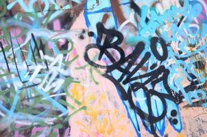 detailopname fragment van een graffiti tekening toegepast naar de muur door aërosol verf. de muur is verwend door een menigte van kleurrijk handtekeningen en tags van straat artiesten en hooligans foto