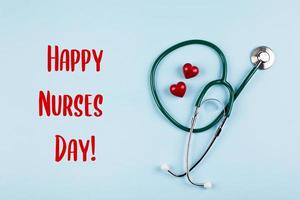 nationaal verpleegster dag vakantie achtergrond. medisch stethoscoop, twee rood harten en houten brieven tekst. foto