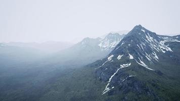 bergen zijn verborgen in laag wolken en mist foto