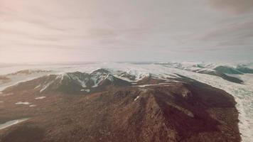 groot sneeuw lap links over- Aan de vulkanisch rots veld- van een berg in zomer foto