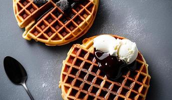 professioneel voedsel fotografie dichtbij omhoog van een bord van belgisch wafels met chocola saus en ijs room Aan een donker grijs achtergrond foto