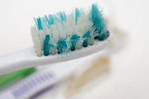een bundel van oud versleten uit tandenborstels met krom borstelharen Aan een wit achtergrond foto