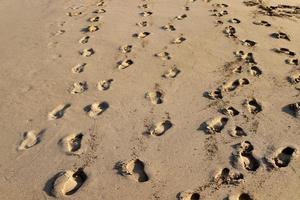 voetafdrukken in het zand bij de zee foto