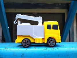 geel vrachtauto speelgoed- auto Aan de blauw oppervlak. kinderen speelgoed pret tijd. foto