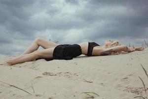 sensueel kaal dame aan het liegen Aan strand toneel- fotografie foto