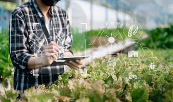 slim boer gebruik makend van toepassing door tablet concepten modern agrarisch technologie en zichtbaar icoon. foto