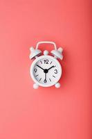 wit retro alarm klok Aan roze achtergrond. concept van tijd met vrij ruimte voor tekst. foto