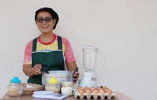 punt van senior Aziatisch vrouw koken, draagt pet en goedkeuren, bereiden Koken. concept, Koken voor familie. Thais keuken levensstijl. ouderen werkzaamheid. foto