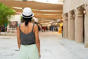 dubai, uae , 2022 - vrouw toerist wandelen Aan oud Dubai onderzoeken Oppervlakte en souvenir winkels foto