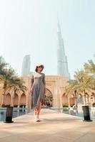 dubai, vae, 2022 - Kaukasisch vrouw toerist Aan vakantie houding wandelen in paleis downtown - beroemd foto locaties in Dubai door palmen en zwembad
