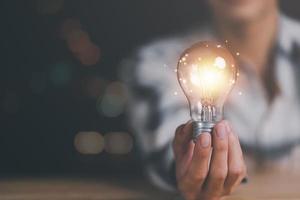 oplossing concept en demonstreren leiderschap strategieën, dat lood de bedrijf in een geslaagd richting, met innovatie en hersenen macht van brainstormen, licht lamp in menselijk hand- foto