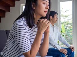 depressief jong vrouw voelt haatdragend en verdrietig. na een argument met een eigenwijs man zittend Aan de sofa ongelukkig jong vrouwen verveeld met slecht verhoudingen, verveeld met huwelijk problemen foto