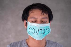 Aziatisch Mens zich zorgen maken en angsten vervelend masker, schrijft covid-19 de situatie van de 2019-ncov virus infectie in wuhan is verspreiden allemaal over- de wereld. dodelijk pest van de wereld gemaskeerd concept naar beschermen foto