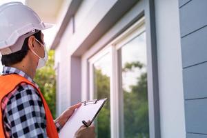 een inspecteur of ingenieur is inspecteren en inspecteren een gebouw of huis gebruik makend van een controlelijst. ingenieurs en architecten werk naar bouwen de huis voordat overhandigen het over- naar de huiseigenaar. foto