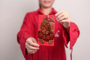 vrouw Holding Chinese rood envelop met gouden konijn en zegen woord, geld geschenk voor gelukkig maan- nieuw jaar vakantie. Chinese zin middelen geluk, gezond, Lucky en rijk foto