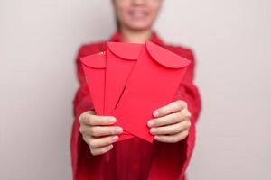 vrouw Holding Chinese rood envelop, geld geschenk voor gelukkig maan- nieuw jaar vakantie foto