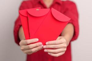 vrouw Holding Chinese rood envelop, geld geschenk voor gelukkig maan- nieuw jaar vakantie foto