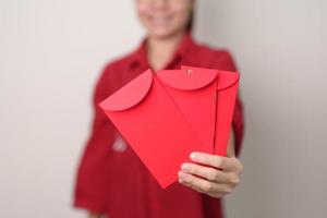 vrouw Holding Chinese rood envelop, geld geschenk voor gelukkig maan- nieuw jaar vakantie foto