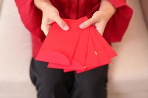vrouw Holding Chinese rood envelop, geld geschenk voor gelukkig maan- nieuw jaar vakantie foto