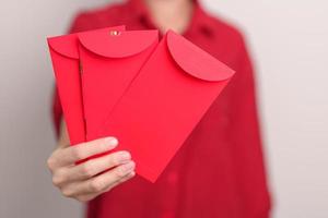 vrouw Holding Chinese rood envelop, geld geschenk voor gelukkig maan- nieuw jaar vakantie foto