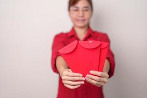 vrouw Holding Chinese rood envelop, geld geschenk voor gelukkig maan- nieuw jaar vakantie foto