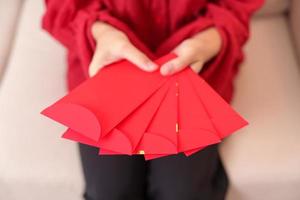 vrouw Holding Chinese rood envelop, geld geschenk voor gelukkig maan- nieuw jaar vakantie foto