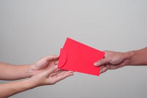 mensen hand- geven Chinese rood envelop, geld geschenk voor gelukkig maan- nieuw jaar vakantie foto