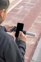 jong Mens Aan een elektrisch scooter gebruik makend van smartphone GPS toepassingen foto