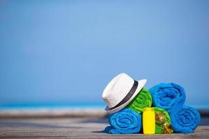 handdoeken, hoed en zonnebrandcrème op een strand foto