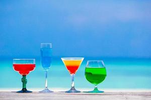 kleurrijke cocktails tegen een blauwe oceaan foto