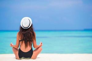 vrouw mediteren op het strand foto