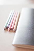 kleurpotloden met een zwart notitieboekje foto
