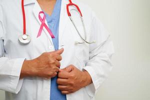 Aziatisch vrouw dokter met roze lint, wereld borst kanker dag Bij oktober. foto