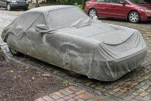 auto gedekt door dekzeil in de straat foto