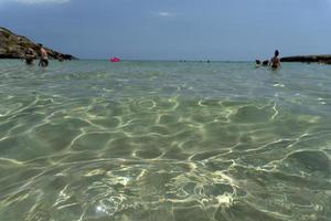 niet, Italië - juli 18 2020 - calamosche strand vol van mensen met Nee sociaal afstand nemen na coronavirus quarentine foto