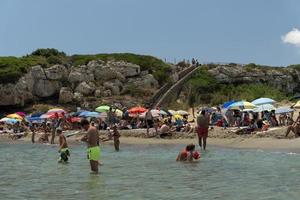 niet, Italië - juli 18 2020 - calamosche strand vol van mensen met Nee sociaal afstand nemen na coronavirus quarentine foto