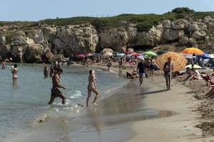 niet, Italië - juli 18 2020 - calamosche strand vol van mensen met Nee sociaal afstand nemen na coronavirus quarentine foto