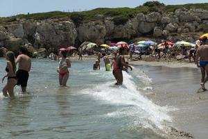 niet, Italië - juli 18 2020 - calamosche strand vol van mensen met Nee sociaal afstand nemen na coronavirus quarentine foto
